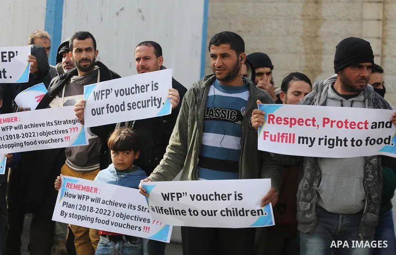 Palestinians hold banners during a protest against aid cut, in front of United Nations Development Programme office (UNDP), in Gaza City January 17, 2018. Photo by Mohammed Asad