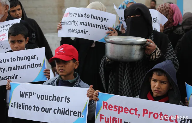 Palestinians hold banners during a protest against aid cut, in front of United Nations Development Programme office (UNDP), in Gaza City January 17, 2018. Photo by Mohammed Asad