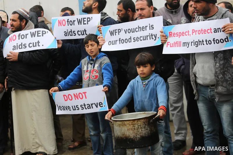 Palestinians hold banners during a protest against aid cut, in front of United Nations Development Programme office (UNDP), in Gaza City January 17, 2018. Photo by Mohammed Asad