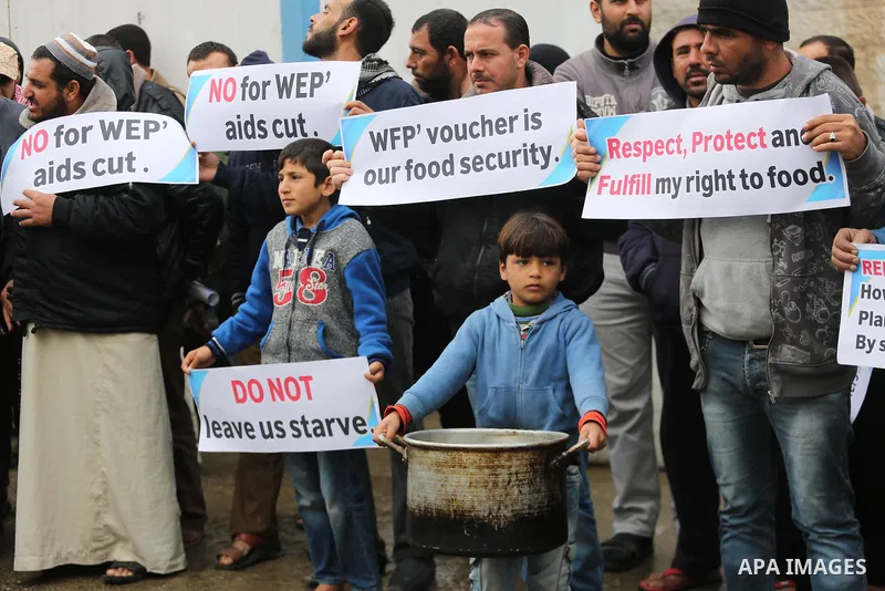 Palestinians hold banners during a protest against aid cut, in front of United Nations Development Programme office (UNDP), in Gaza City January 17, 2018. Photo by Mohammed Asad
