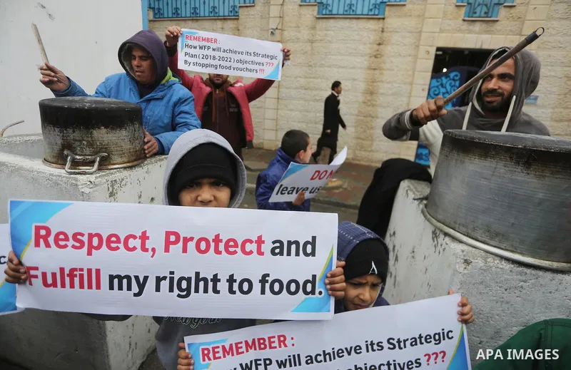 Palestinians hold banners during a protest against aid cut, in front of United Nations Development Programme office (UNDP), in Gaza City January 17, 2018. Photo by Mohammed Asad