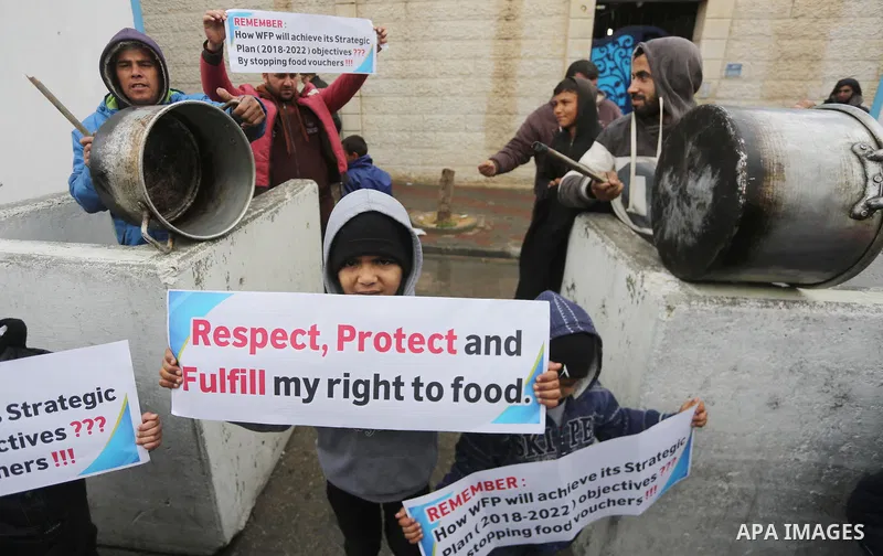 Palestinians hold banners during a protest against aid cut, in front of United Nations Development Programme office (UNDP), in Gaza City January 17, 2018. Photo by Mohammed Asad