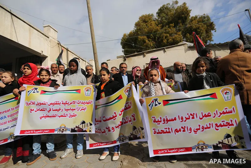 Palestinians hold banners during a protest against aid cut, in front of the headquarters United Nations Relief and Works Agency (UNRWA) in al-Nusirat refugee camp in the Gaza strip on January 17, 2018 after the White Hou...