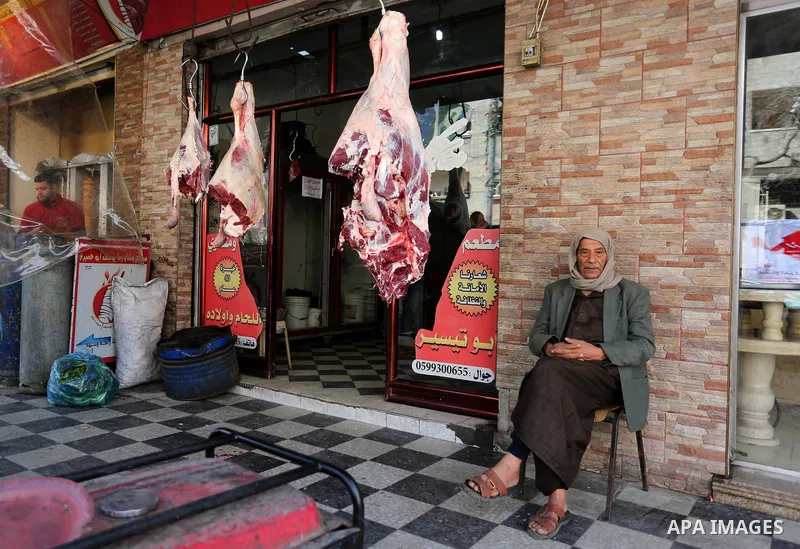 A Palestinian man sits outside his meat shop in al-Nusirat refugee camp in the Gaza strip on January 17, 2018. Gazans are strapped for cash and markets are suffering from an unprecedented recession. Meanwhile, on Dec. 30...