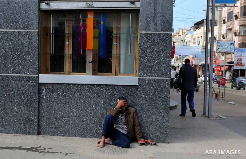 A Palestinian beggar sits on the street in al-Nusirat refugee camp in the Gaza strip on January 17, 2018. Gazans are strapped for cash and markets are suffering from an unprecedented recession. Meanwhile, on Dec. 30, for...