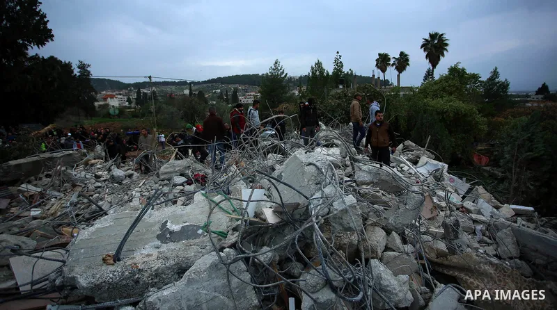 Palestinians stand on the rubble of the house of Palestinian gunman Ahmed Jarrar following an Israeli raid in the occupied West Bank, after it was demolished overnight on January 18, 2018 in Jenin. A Palestinian was kill...