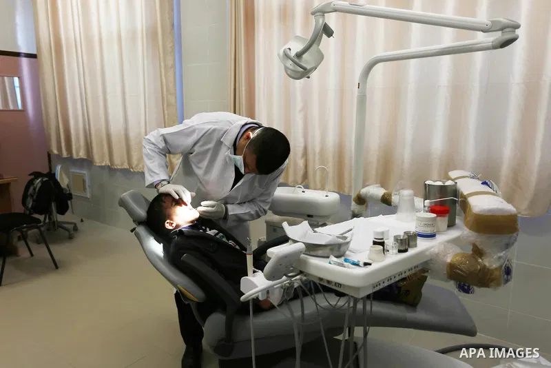 A Palestinian doctor treats a child at an UNRWA-run clinic at al-Shati refugee camp in Gaza city on January 18, 2018. U.S. President Donald Trump is preparing to withhold tens of millions of dollars from UNRWA, the UN ag...