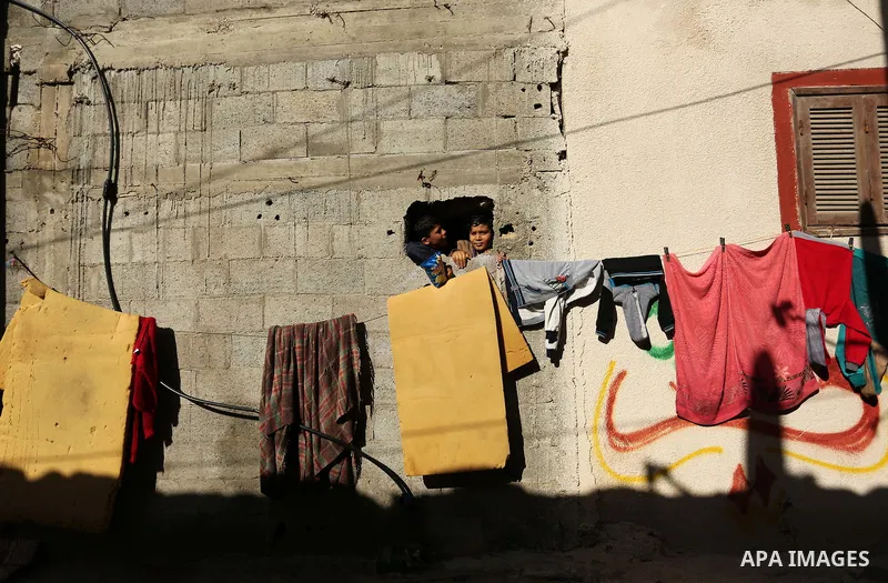Palestinian children look through a window in al-Shati refugee camp in Gaza city on January 18, 2018. Photo by Ashraf Amra