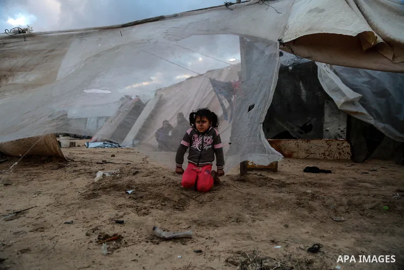 A Palestinian girl stands outside their family dwelling after it was damaged by the storm in Rafah in the southern Gaza Strip on January 19, 2018. Photo by Mohammed Dahman