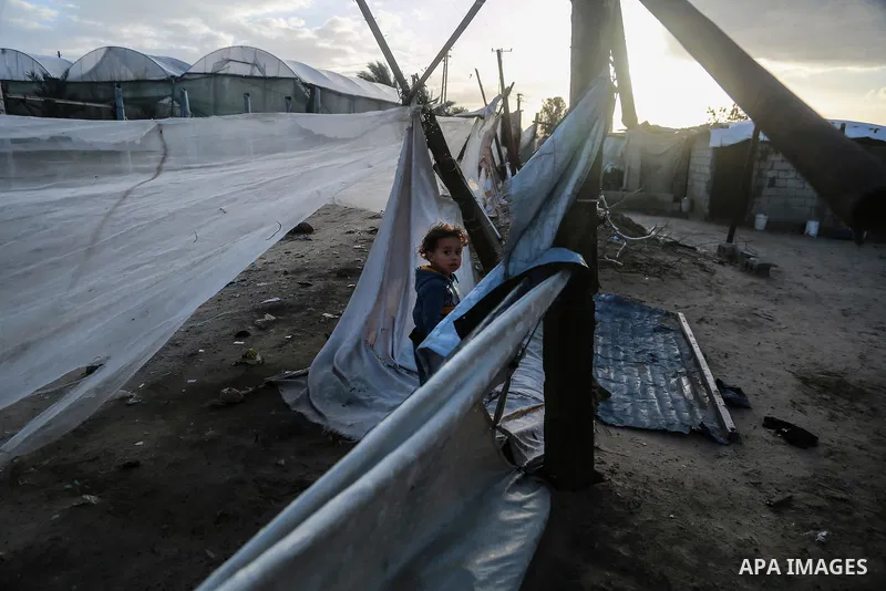 A Palestinian girl stands outside her family dwelling after it was damaged by the storm in Rafah in the southern Gaza Strip on January 19, 2018. Photo by Mohammed Dahman