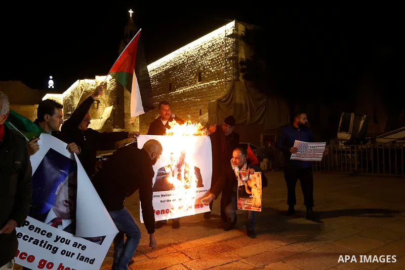 Palestinian protesters burn posters bearing portraits of US Vice President Mike Pence during a demonstration at the Manger Square in the town of Bethlehem in the occupied West Bank, on January 21, 2018. Pence arrived in...