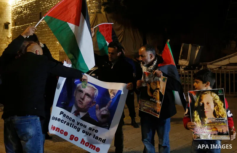 Palestinian protesters burn posters bearing portraits of US Vice President Mike Pence during a demonstration at the Manger Square in the town of Bethlehem in the occupied West Bank, on January 21, 2018. Pence arrived in...