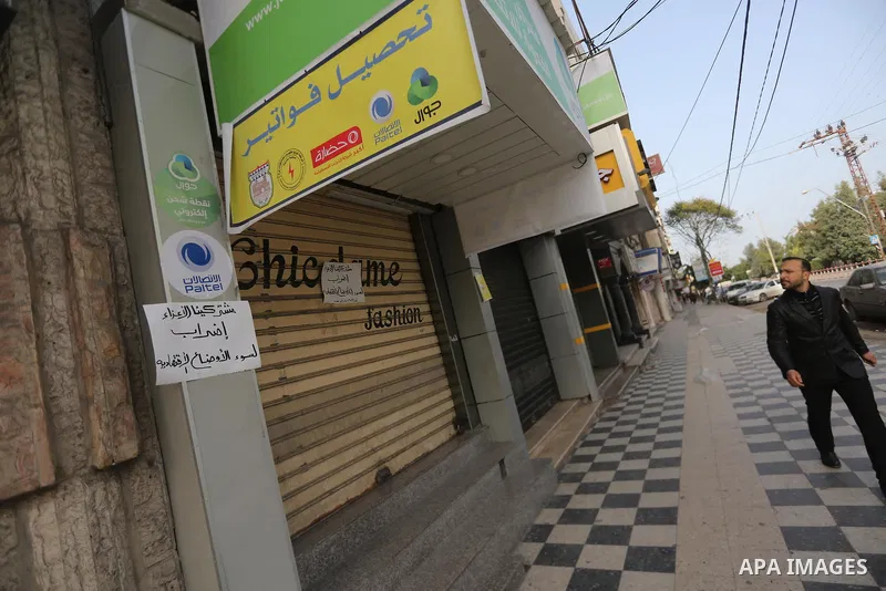A Palestinian walks past closed shops during a general strike in Gaza city on January 22, 2018. Gazans are strapped for cash and markets are suffering from an unprecedented recession. Meanwhile, on Dec. 30, for the first...