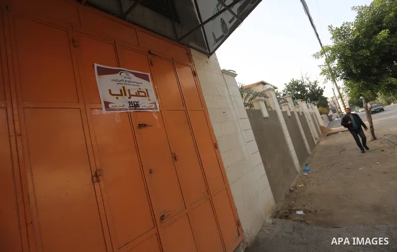 A Palestinian walks past closed shops during a general strike in Gaza city on January 22, 2018. Gazans are strapped for cash and markets are suffering from an unprecedented recession. Meanwhile, on Dec. 30, for the first...