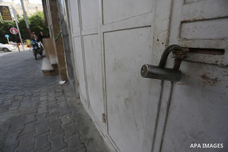 A Palestinian walks past closed shops during a general strike in Gaza city on January 22, 2018. Gazans are strapped for cash and markets are suffering from an unprecedented recession. Meanwhile, on Dec. 30, for the first...