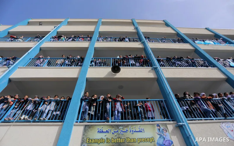 Palestinian schoolgirls pose for a group picture outside their classrooms at a school belonging to the United Nations Relief and Works Agency for Palestine Refugees (UNRWA) in Gaza City on January 22, 2018, during a visi...