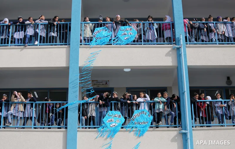 Palestinian schoolgirls pose for a group picture outside their classrooms at a school belonging to the United Nations Relief and Works Agency for Palestine Refugees (UNRWA) in Gaza City on January 22, 2018, during a visi...