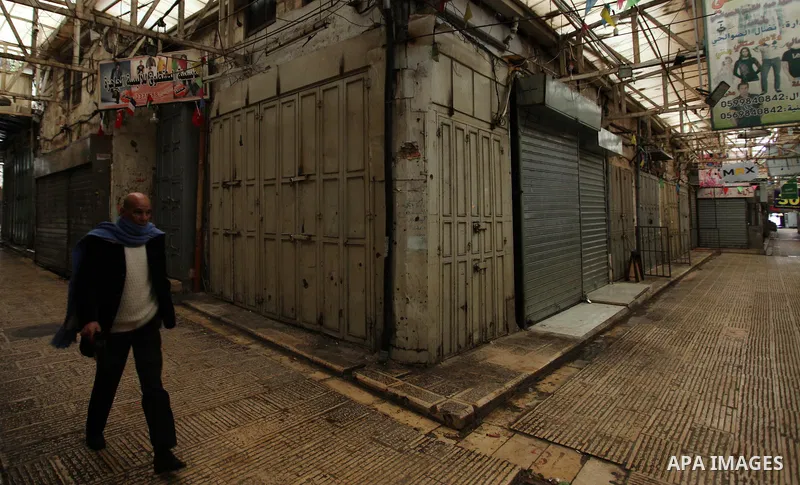 A picture taken on January 23, 2018 shows people walking past closed shops in an alley in the city of Nablus in the occupied West Bank, as people go on strike protesting against the visit of US Vice President Mike Pence...