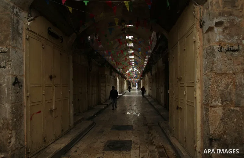 A picture taken on January 23, 2018 shows people walking past closed shops in an alley in the city of Nablus in the occupied West Bank, as people go on strike protesting against the visit of US Vice President Mike Pence...