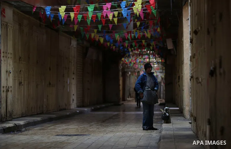 A picture taken on January 23, 2018 shows people walking past closed shops in an alley in the city of Nablus in the occupied West Bank, as people go on strike protesting against the visit of US Vice President Mike Pence...
