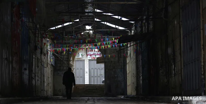A picture taken on January 23, 2018 shows people walking past closed shops in an alley in the city of Nablus in the occupied West Bank, as people go on strike protesting against the visit of US Vice President Mike Pence...