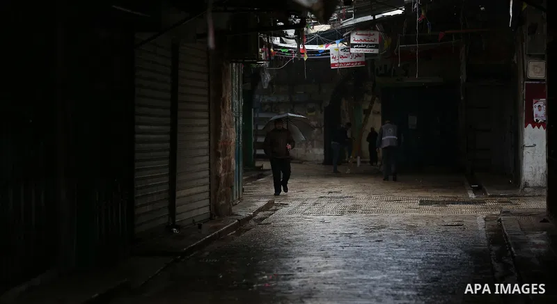 A picture taken on January 23, 2018 shows people walking past closed shops in an alley in the city of Nablus in the occupied West Bank, as people go on strike protesting against the visit of US Vice President Mike Pence...