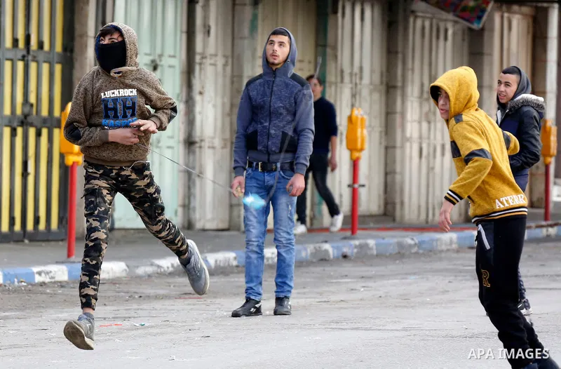 Palestinian protesters clash with Israeli security forces in the city of Hebron in the occupied West Bank, on January 23, 2018, as protests erupted following US Vice Presidents reaffirmation of US President Donald Trump'...