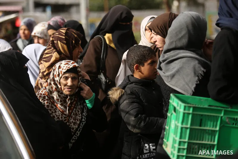 Palestinians of Social Affairs wait in front of Bank of Palestine to withdrew their financial aid in Gaza City on January 23, 2018. Photo by Ashraf Amra