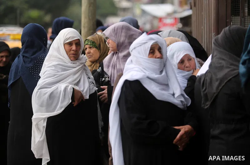 Palestinians of Social Affairs wait in front of Bank of Palestine to withdrew their financial aid in Gaza City on January 23, 2018. Photo by Ashraf Amra