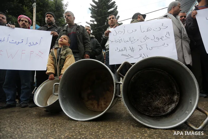 Palestinians hold banners during a protest against aid cut, in front of United Nations Development Programme office (UNDP), in Gaza City January 24, 2018. Photo by Mohammed Asad