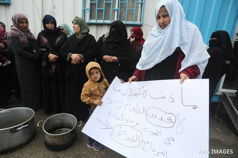 Palestinians hold banners during a protest against aid cut, in front of United Nations Development Programme office (UNDP), in Gaza City January 24, 2018. Photo by Mohammed Asad