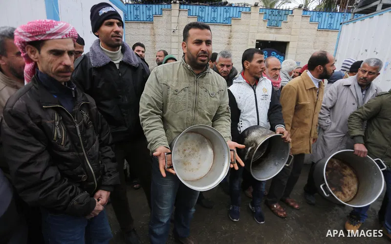 Palestinians hold banners during a protest against aid cut, in front of United Nations Development Programme office (UNDP), in Gaza City January 24, 2018. Photo by Mohammed Asad
