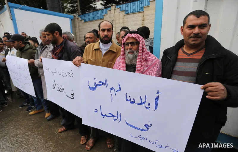 Palestinians hold banners during a protest against aid cut, in front of United Nations Development Programme office (UNDP), in Gaza City January 24, 2018. Photo by Ashraf Amra