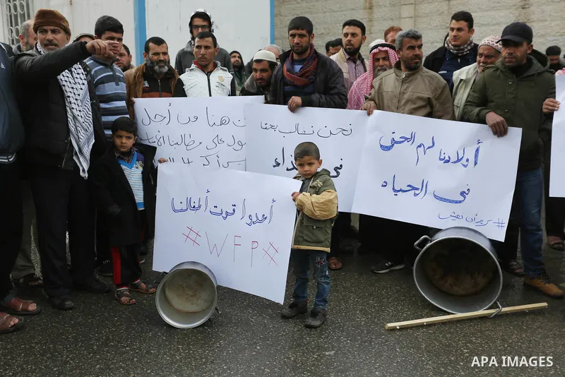 Palestinians hold banners during a protest against aid cut, in front of United Nations Development Programme office (UNDP), in Gaza City January 24, 2018. Photo by Ashraf Amra