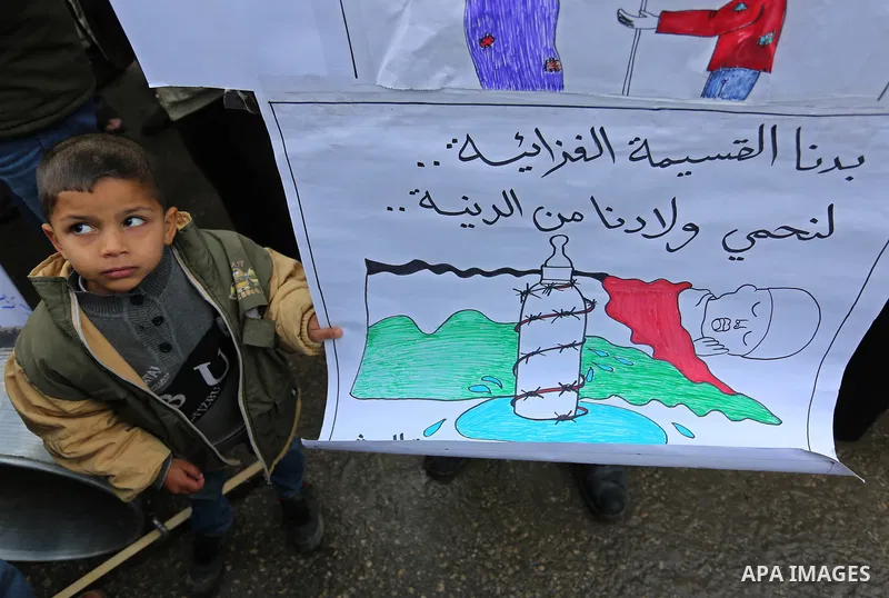 Palestinians hold banners during a protest against aid cut, in front of United Nations Development Programme office (UNDP), in Gaza City January 24, 2018. Photo by Ashraf Amra