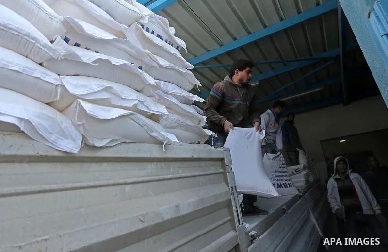 A Palestinian man carries a sack of flour at a United Nations food distribution center in Jabalia in the northern Gaza Strip on January 24, 2018. U.S. President Donald Trump is preparing to withhold tens of millions of d...
