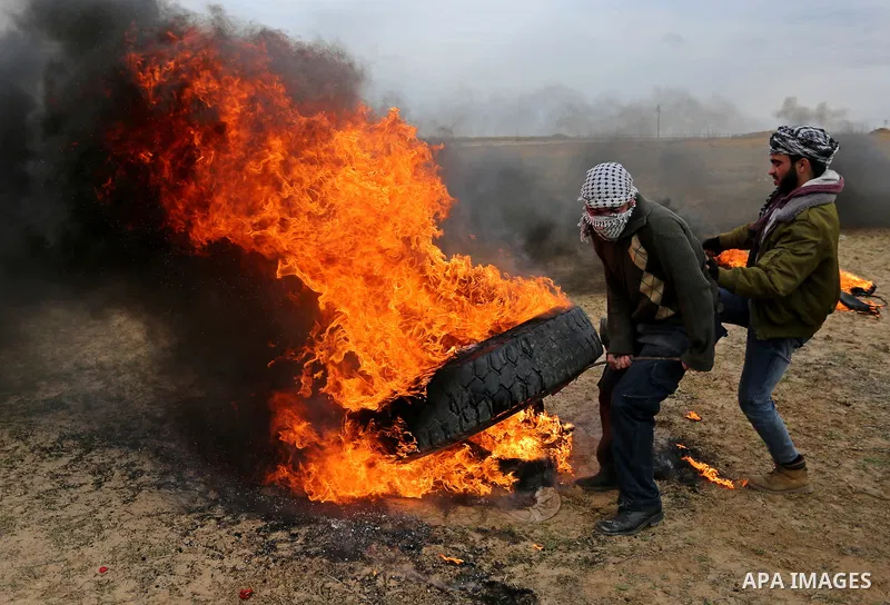 Palestinian protesters burn tires during clashes with Israeli security forces, as Palestinians call for 'a day of rage' against US President Donald Trump's decision to recognise Jerusalem as the capital of Israel, near t...