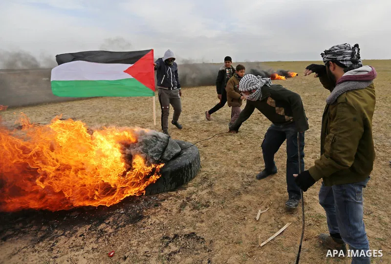 Palestinian protesters burn tires during clashes with Israeli security forces, as Palestinians call for 'a day of rage' against US President Donald Trump's decision to recognise Jerusalem as the capital of Israel, near t...