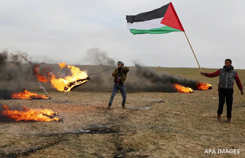 A Palestinian protester holds a fire during clashes with Israeli security forces, as Palestinians call for 'a day of rage' against US President Donald Trump's decision to recognise Jerusalem as the capital of Israel, nea...