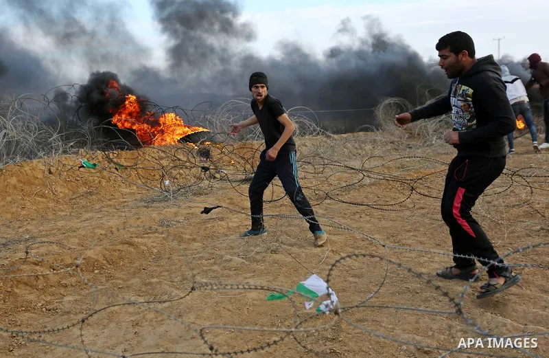 A Palestinian protester removes Israeli fence during clashes with Israeli security forces, as Palestinians call for 'a day of rage' against US President Donald Trump's decision to recognise Jerusalem as the capital of Is...