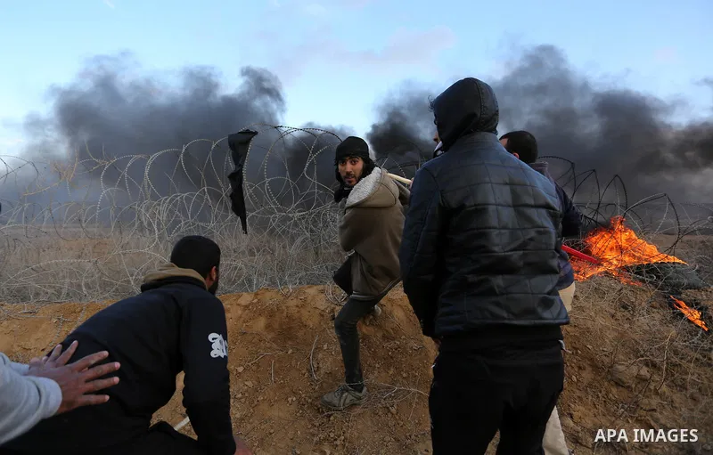 Palestinian protesters remove Israeli fence during clashes with Israeli security forces, as Palestinians call for 'a day of rage' against US President Donald Trump's decision to recognise Jerusalem as the capital of Isra...