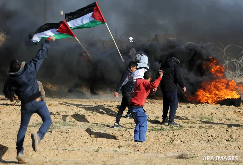 A Palestinian protester uses a slingshot to hurl stones towards Israeli security forces during clashes, as Palestinians call for 'a day of rage' against US President Donald Trump's decision to recognise Jerusalem as the...