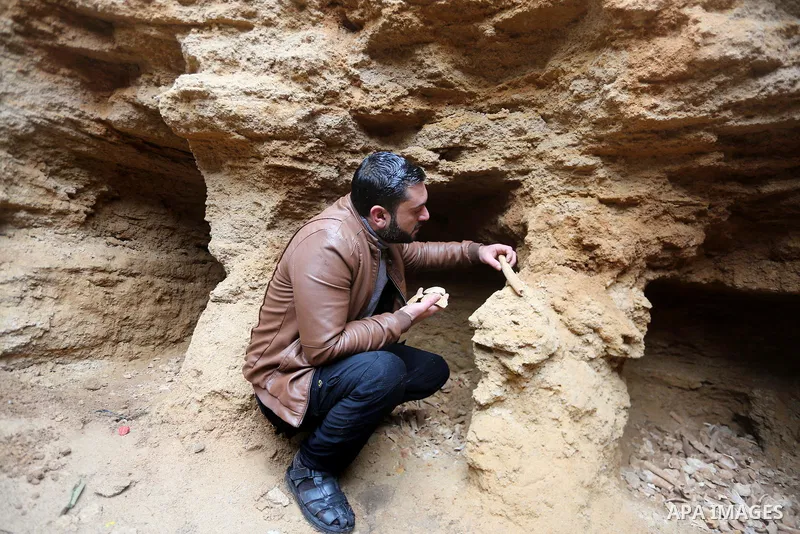 A Palestinian man holds pottery fragments at a freshly-discovered cemetery which was found by Abdelkarim al-Kafarna in his backyard in town of Beit Hanoun, in the northern Gaza strip on January 27, 2018. Experts said the...
