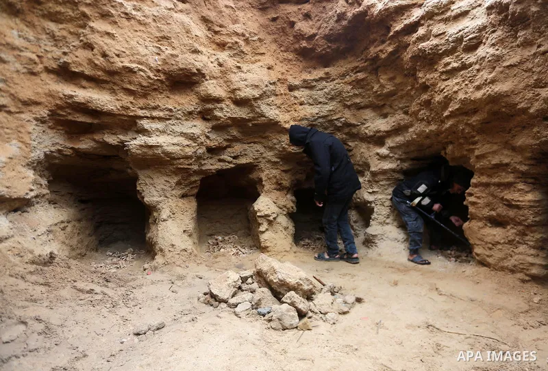 Palestinians gather at a freshly-discovered cemetery which was found by Abdelkarim al-Kafarna in his backyard in town of Beit Hanoun, in the northern Gaza strip on January 27, 2018. Experts said the graves were part of a...