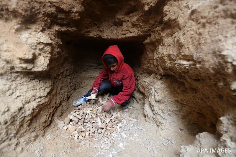 A Palestinian boy holds pottery fragments at a freshly-discovered cemetery which was found by Abdelkarim al-Kafarna in his backyard in town of Beit Hanoun, in the northern Gaza strip on January 27, 2018. Experts said the...