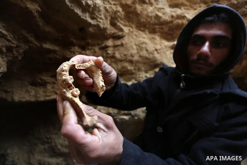 A Palestinian man holds pottery fragments at a freshly-discovered cemetery which was found by Abdelkarim al-Kafarna in his backyard in town of Beit Hanoun, in the northern Gaza strip on January 27, 2018. Experts said the...