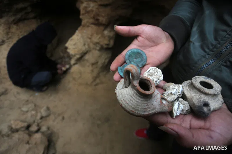 A Palestinian man holds pottery fragments at a freshly-discovered cemetery which was found by Abdelkarim al-Kafarna in his backyard in town of Beit Hanoun, in the northern Gaza strip on January 27, 2018. Experts said the...