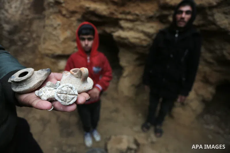 A Palestinian man holds pottery fragments at a freshly-discovered cemetery which was found by Abdelkarim al-Kafarna in his backyard in town of Beit Hanoun, in the northern Gaza strip on January 27, 2018. Experts said the...