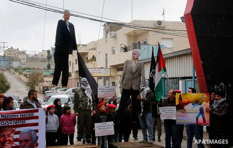 Palestinians hang a puppet bearing the portrait of US President Donald Trump, during a mock trial for him and Vice President Mike Pence in the Aida refugee camp in the West Bank city of Bethlehem on January 27, 2018. Pho...