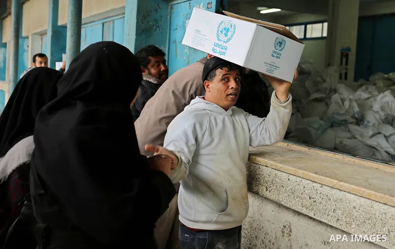 Palestinian refugees collect aid parcels at a United Nations food distribution centre in Khan Yunis in the southern Gaza Strip on January 28, 2018. On January 16, Washington held back $65 million that had been earmarked...